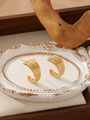 Close-up of golden wavy texture C-shaped earrings on a vintage relief tray decoration - Hammered Wave Style (ZHE2118) / Gold