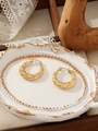 Close-up of golden wide hoop earrings with embossed texture on an elegant white tray - Embossed Engraved Wide Hoop (ZHE2119) / Gold