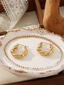 Dettaglio di orecchini a cerchio intrecciati dorati su un vassoio per gioielli - Stile Intreccio Croissant Francese (ZHE2121) / Oro