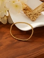 Bracciale elastico con perline dorate lucide su un elegante vassoio in ceramica bianca - Stile a Sfera 2mm (ZHB1207) / Oro