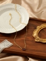 Detailed shot of a gold paperclip chain necklace with a purple rectangular gemstone - Deep purple