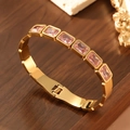 Detail view of 18K gold plated bangle with seven pink rectangular crystals and clasp - 18K Gold / Pink