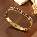 Detailed macro shot of vintage 18K gold plated bangle with seven purple crystals - 18K Gold / Purple