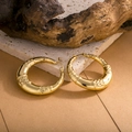 Detailansicht der goldenen Bambus-Creolen auf natürlichem Fels- und Holzhintergrund - Bambus-Creolen (ZHE964) / Gold