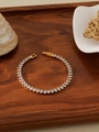 Detail of 18k gold plated tennis bracelet with clear oval-cut zircon on wood tray - White Rhinestone (ZHB712)