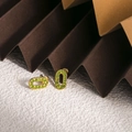 Gros plan de boucles d'oreilles ovales dorées avec zircons verts pavés sertis - Zirconia Vert Pomme (ZHE1981)