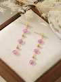Detail of floral drop earrings with purple and pink beads on a textured rustic background - Rose Red (ZHE1817)