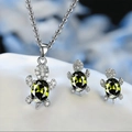 Detailed close-up of sea turtle jewelry set with green stones and silver finish - Green