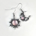 Detalle de pendientes vintage de plata con sol y luna e incrustaciones de piedras rosas - Rosa