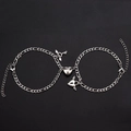 Detail of couple bracelets with magnetic heart, wing key and lock on Figaro chain - Heart Key Bracelet B