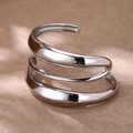 Dettaglio macro della struttura a tripla spirale del bracciale rigido in argento lucido - Spirale a Triplo Strato / Colore acciaio