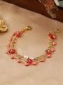 Detailed macro view of triple-layered gold bracelet with floral and heart charms on satin - Red Flower Pink Heart Style (ZHB873 Gold)