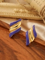 Détail de boucles d'oreilles en émail violet et métal doré sur un plateau vintage en bois - Or Violet