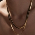Primo piano di una collana a doppio strato in maglia serpente dorata con riflessi lucidi - Catena a Serpente Minimalista a Doppio Strato (ZHN1106金) / Oro 18K