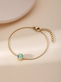 Dettaglio di un bracciale minimalista dorato con una gemma rotonda di colore azzurro - Bracciale con Pietra Blu Chiaro (ZHB600) / Oro