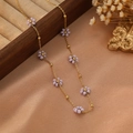 Détail d'un collier chaîne dorée avec fleurs en perles mauves sur une boîte élégante - Style Violet Clair (ZHN2316 Or)