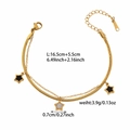 Detalle de una pulsera de doble capa en acero de titanio dorado con estrellas - Estilo Doble Capa Estrellas Blanco Negro (ZHB476金)