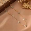 Dettaglio dell'elegante collana in acciaio inossidabile dorato con piccoli fiori di perle - Stile Bianco Sporco (ZHN2324 Oro)