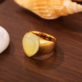 Gros plan sur une bague dorée en acier inoxydable avec une grande pierre ovale jaune clair - Taille 7 / Style Face d'œuf Œil de Tigre (ZHR210)