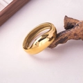 Gros plan d'un bracelet jonc doré poli sur bois naturel avec des ombres douces - Style de Forme de Larme Lourde / Or