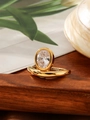 Dettaglio dell'anello in titanio dorato con gemma ovale e incisione Lola&Flo su legno - Taglia 7 / Oro con pietra preziosa trasparente
