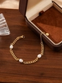Dettaglio macro del bracciale con perle in acciaio inossidabile dorato su legno - Bracciale a Catena Cubana con 3 Perle in Acciaio Inossidabile Oro