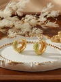 Close-up of chunky gold hoop earrings with green enamel stripes on a white ceramic tray - Light Green Stripe Style (ZHE412-浅绿)