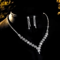 Detailed view of elegant bridal zircon necklace and earrings set on a dark mannequin display - Silver White V-Shaped Drop Set (PJ--T0042--1)
