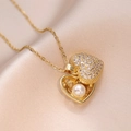 Detailed close-up of a golden heart pendant necklace with micro-paved cubic zirconia and pearl - Gold Pearl Heart Style