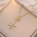 Goldene Schneeflocken-Halskette mit Perle und Zirkonia auf Schmuckständer - Halskette mit Anhänger / Gold