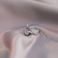 Dettaglio del ciondolo a forma di coniglio con zirconi lucidi su sfondo di seta champagne - Anello a Coniglio Rotante Colore Acciaio