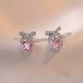 Primer plano de pendientes de corazón con circón rosa y detalle de lazo brillante - Pendientes de Circonita Con Corazón Rosa y Lazo (E0357)