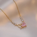 Detailed macro view of heart-shaped pendant with pink zircon on champagne satin fabric - Gold