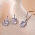 Parure de bijoux argentés avec zircons rectangulaires taille émeraude sur satin champagne - Ensemble collier et boucles d'oreilles / Acier