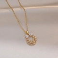 Detailed shot of golden horseshoe pendant with sparkling heart and baguette cut zircons - Gold Zirconia Bowknot Necklace