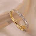 Nahaufnahme des goldenen Armreifs mit Zirkonia im Marquise-Schliff auf Satinstoff - Weißer Zirkonia (TS165)