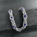 Detailed close-up of handmade steel chain bracelet with deep blue beads on black pedestal - Dark Blue