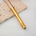 Primer plano de un colgante de respiración de oro pulido en una fina cadena cruzada - Tubo Roscado / Dorado