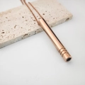 Detalle macro del collar de respiración en oro rosa con diseño cilíndrico hueco - Tubo Roscado / Rosa oro