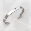 Macro shot of minimalist silver-tone open metal bracelet with a smooth flat surface - Minimalist Polished Silver Style