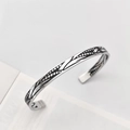 Close-up of vintage silver cuff bracelet with black leaf patterns and open design - Vintage Feather Texture Silver Style