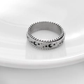 Detail view of silver spinner ring with embossed moon and star patterns for stress relief - US 6 / Steel
