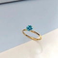 Goldener Edelstahlring mit rundem, dunkelblauem Zirkon in einer klassischen Vier-Krallen-Fassung - US 6 / Dezember Seeblau - Gold