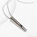 Polished silver stainless steel whistle pendant necklace on white ceramic surface - Steel