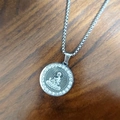 Silver zodiac Buddha pendant necklace with sparkling crystals on dark wooden background - Steel - Buddha Amulet / Steel