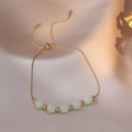 Close-up of adjustable gold chain bracelet featuring five green luminous stone beads - Gold Moonstone Style (TS088)