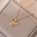 Elegante goldene Schleifenhalskette mit glitzernden Zirkonien auf einer Schmuckbox - Schleife Halskette (Inklusive Anhänger) / Gold