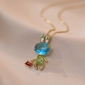 Détail d'un pendentif lapin doré serti de pierres précieuses bleues, vertes et rouges - Lapin Doré (X0649)