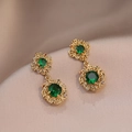 Detail of vintage gold earrings with emerald green crystals on champagne silk background - Gold Emerald Earrings