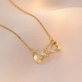 Elegant gold infinity symbol necklace with micro-set crystals on champagne satin background - Infinity Necklace (X0689--1) / Gold